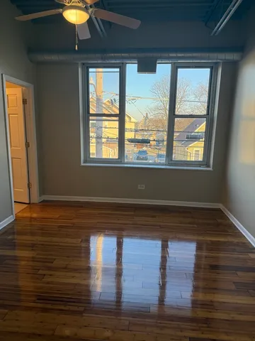 a view of empty room with wooden floor and window