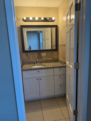 a bathroom with a granite countertop sink and a mirror