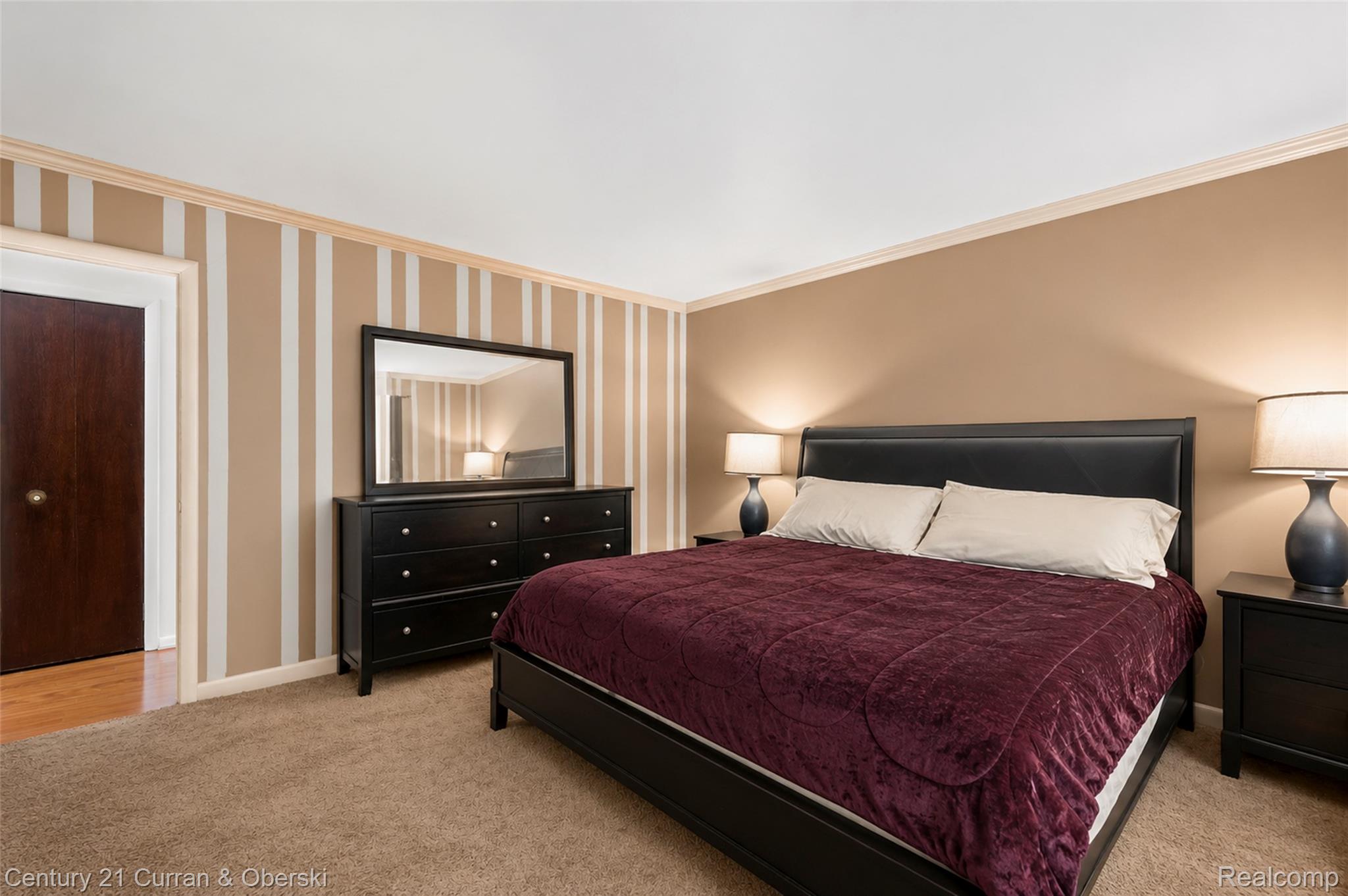 4652 Patrick Road West Bloomfield, MI 48322 - Photo 18 of 27 Carpeted bedroom featuring a dark wood door, striped accent wall, and crown molding