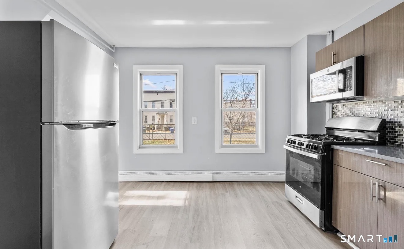 a kitchen with stainless steel appliances granite countertop a stove a sink and a refrigerator