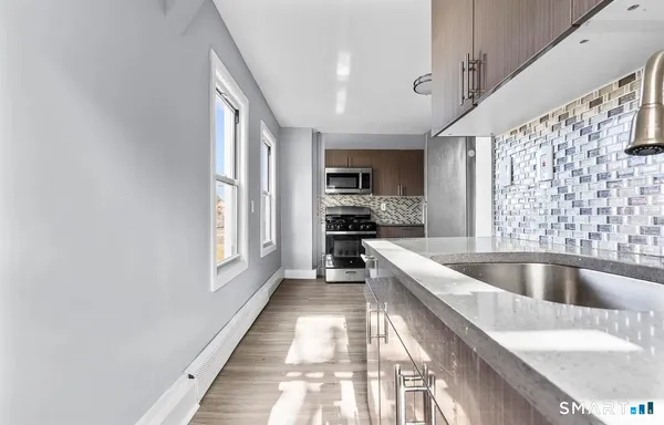 a large kitchen with a large window and stainless steel appliances