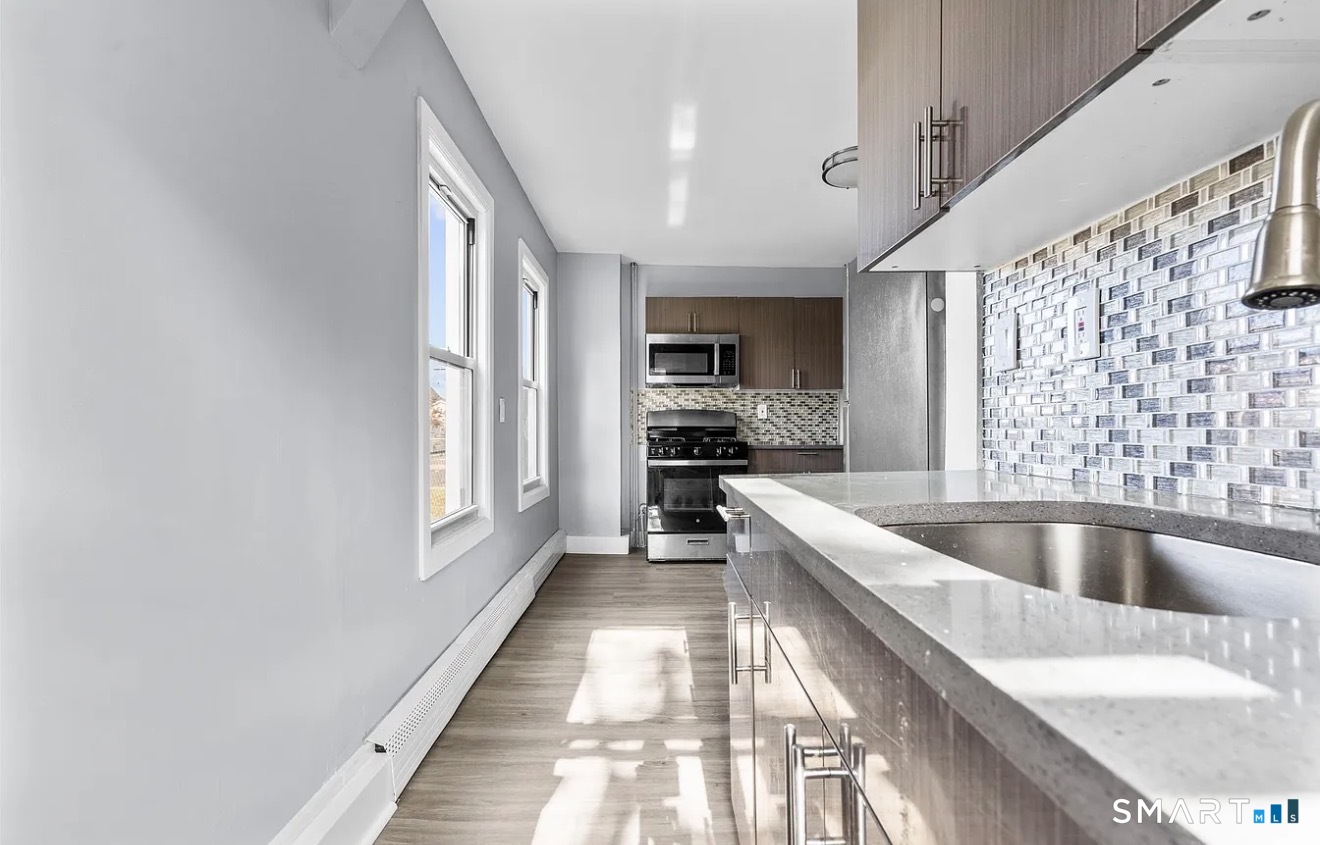 746 Maple Street Bridgeport, CT 06608 - Photo 4 of 12 a large kitchen with a large window and stainless steel appliances