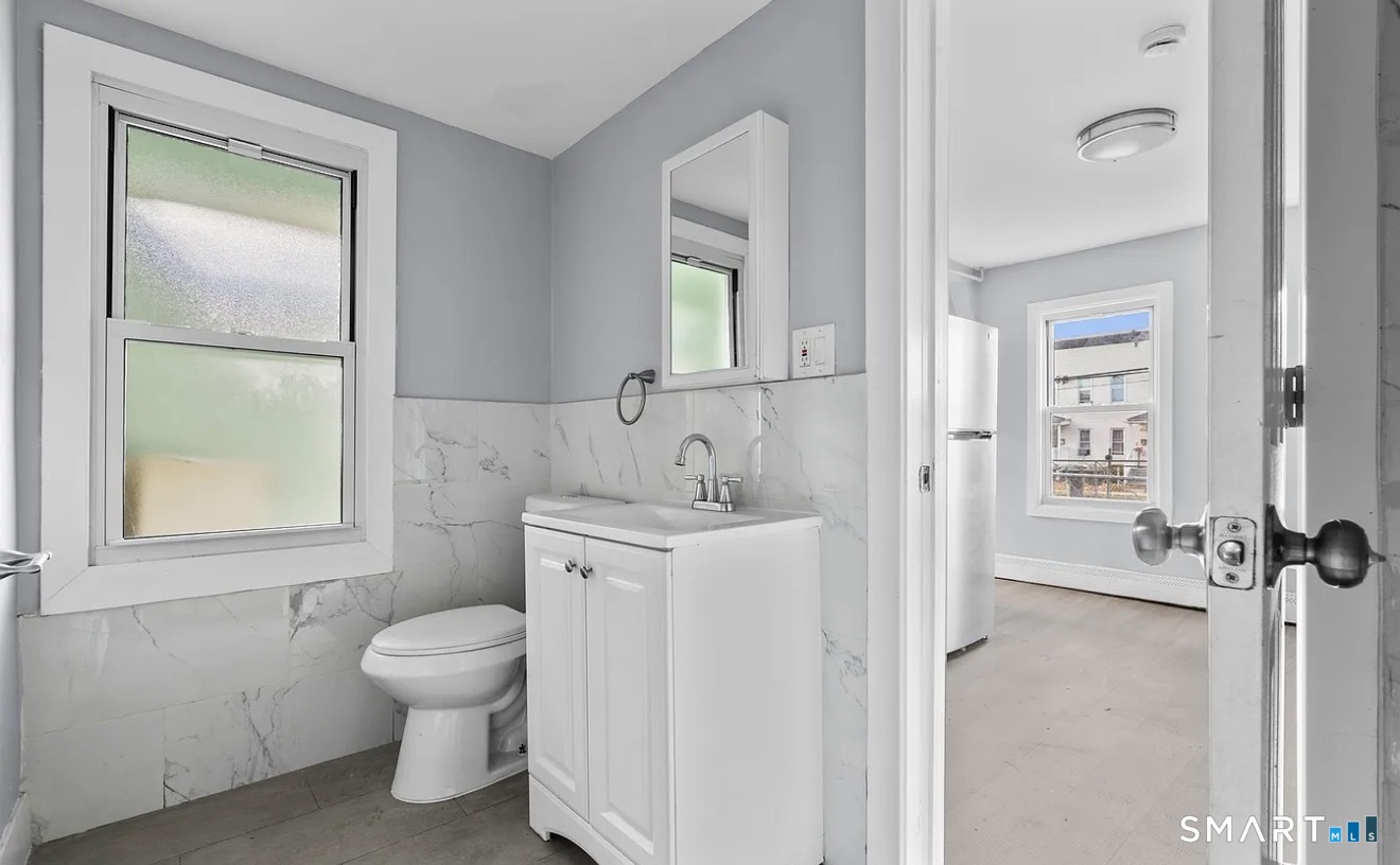 746 Maple Street Bridgeport, CT 06608 - Photo 8 of 12 a spacious bathroom with a toilet sink and a mirror