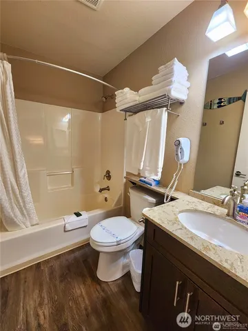 a bathroom with a granite countertop sink toilet and shower