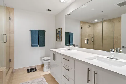 a bathroom with a double vanity sink mirror and toilet
