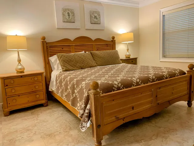 a bed sitting in a bedroom next to a lamp