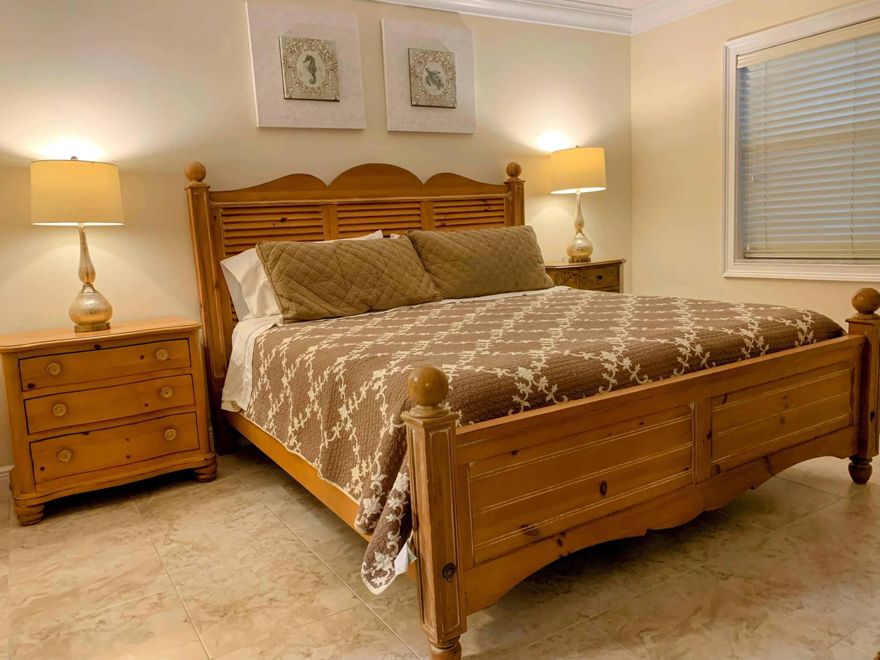 3101 South Ocean Boulevard, Unit 712 Highland Beach, FL 33487 - Photo 11 of 25 a bed sitting in a bedroom next to a lamp