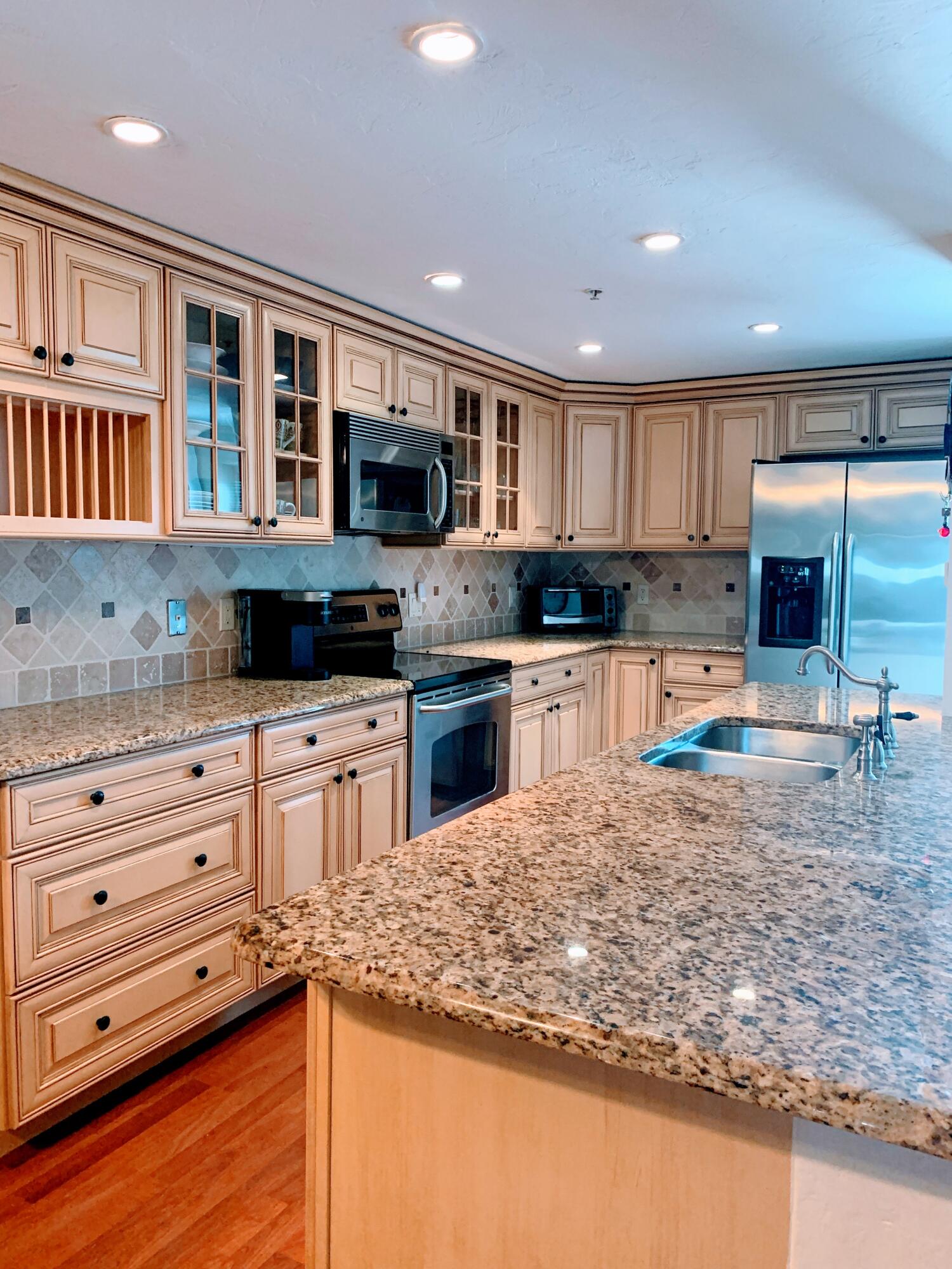 3101 South Ocean Boulevard, Unit 712 Highland Beach, FL 33487 - Photo 4 of 25 a kitchen with stainless steel appliances granite countertop a sink and a stove