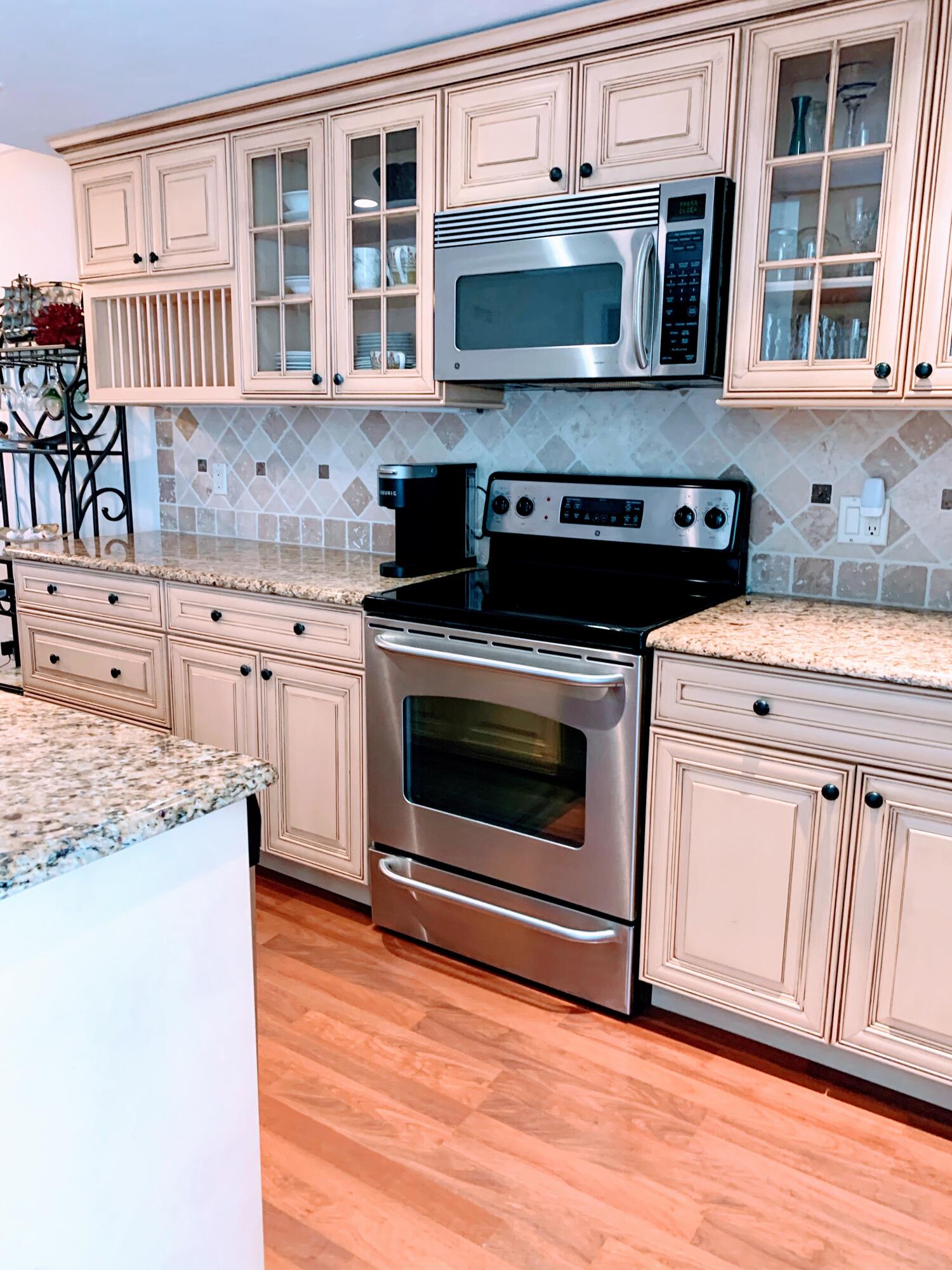 3101 South Ocean Boulevard, Unit 712 Highland Beach, FL 33487 - Photo 5 of 25 a kitchen with stainless steel appliances granite countertop a stove microwave and cabinets