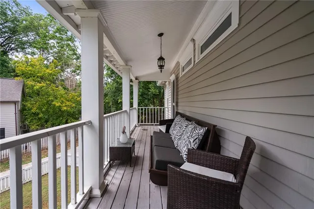 a balcony with wooden floor outdoor seating and stairs