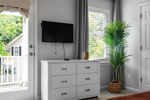 a living room with flat screen tv and a potted plant