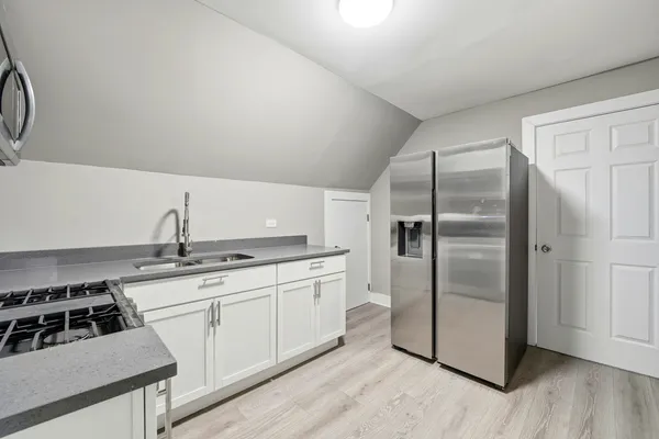 a kitchen with stainless steel appliances granite countertop a stove a sink and a microwave