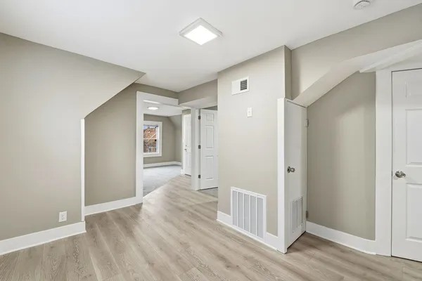 a view of a hallway with wooden floor and closet area