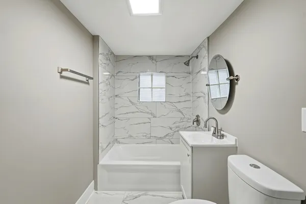 a bathroom with a toilet sink and mirror
