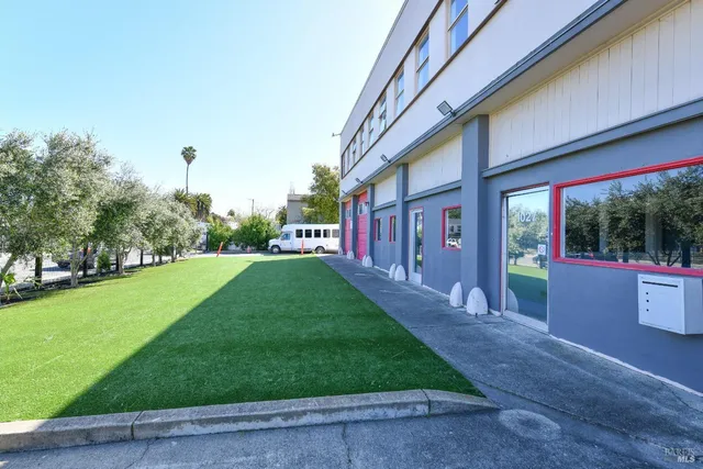 a view of a house with a yard and a park
