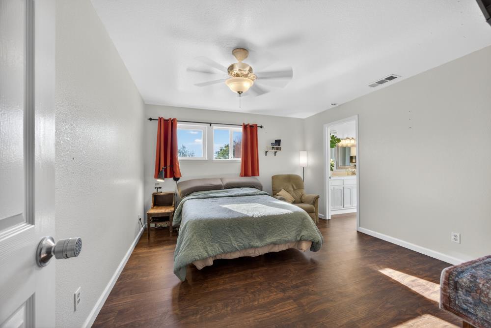13512 Alta Mesa Road Galt, CA 95632 - Photo 35 of 99 a bedroom with a bed and a chandelier