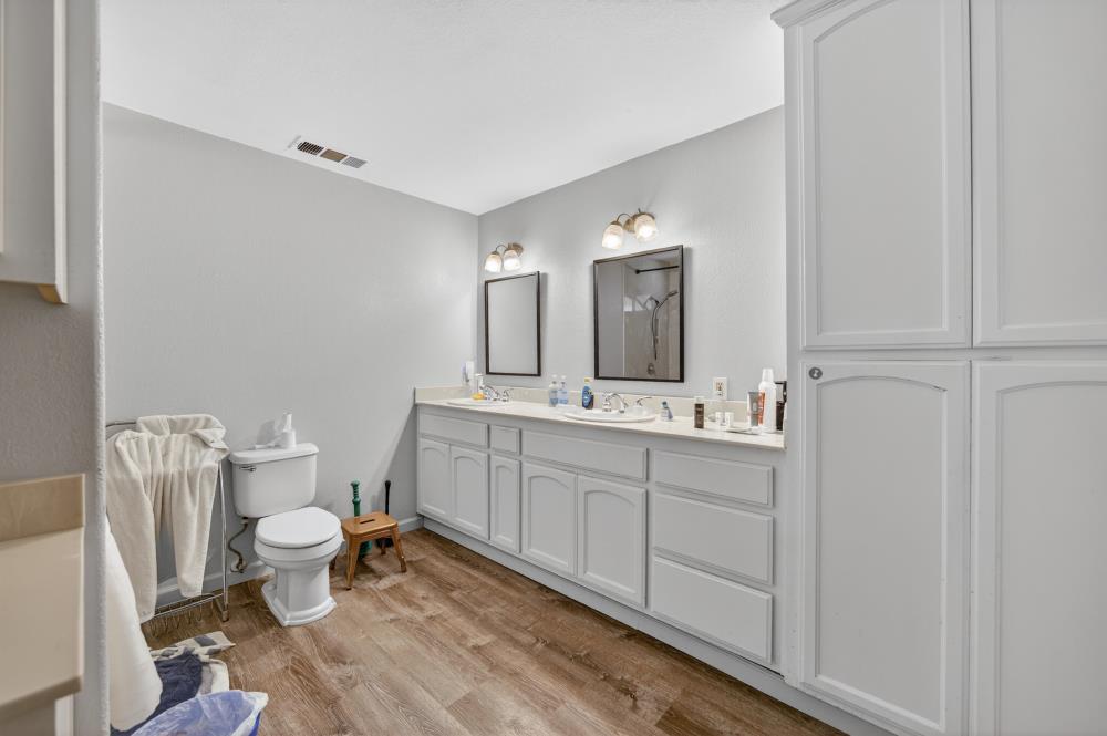 13512 Alta Mesa Road Galt, CA 95632 - Photo 47 of 99 a bathroom with a double vanity sink mirror and toilet