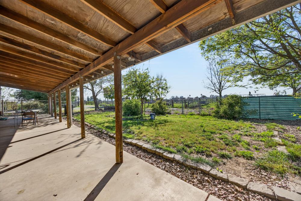 13512 Alta Mesa Road Galt, CA 95632 - Photo 50 of 99 a view of a patio with table and chairs and wooden fence