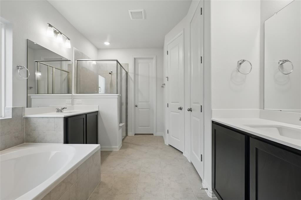 2521 Rivers West Road Anna, TX 75409 - Photo 16 of 40 a spacious bathroom with a granite countertop sink a toilet a large mirror a bathtub and shower
