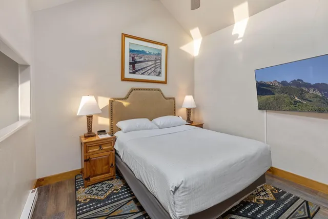 a bedroom with a bed and a wall painting