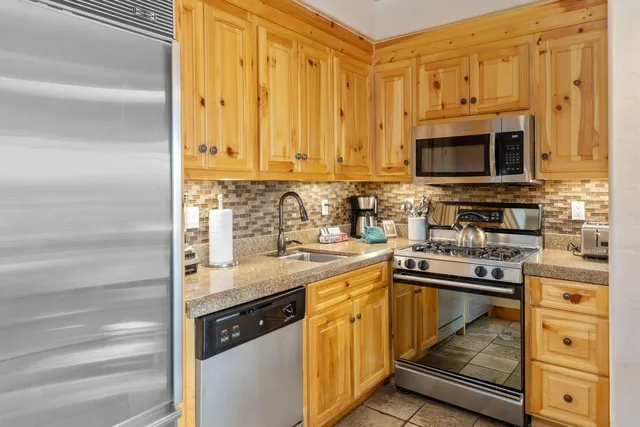 a kitchen with stainless steel appliances granite countertop a sink stove and cabinets