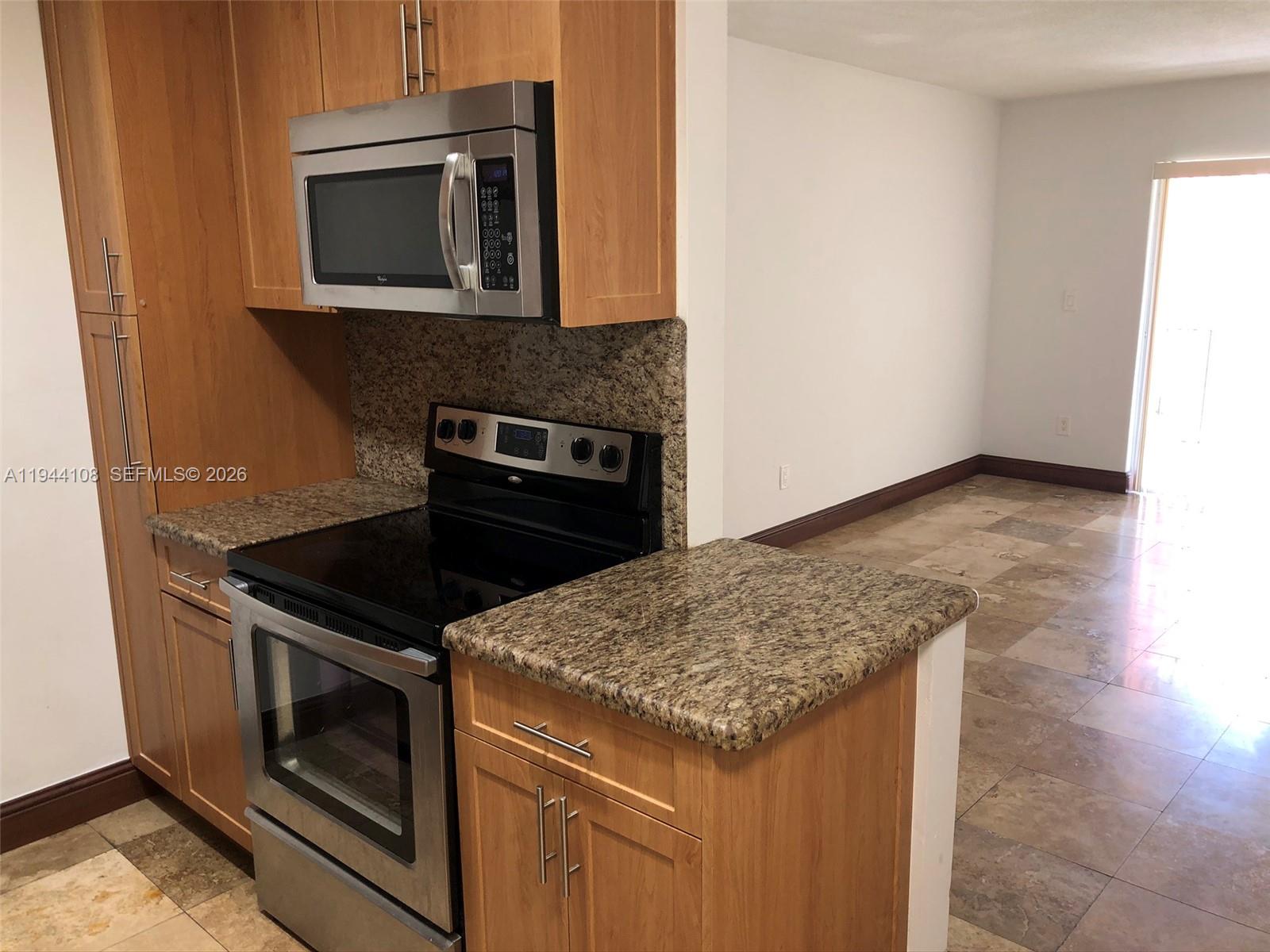 10794 North Kendall Drive, Unit B14 Miami, FL 33176 - Photo 5 of 23 a kitchen with granite countertop cabinets stove and microwave