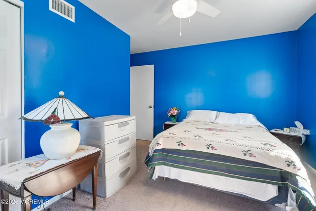 a bed sitting in a bedroom next to a window with wooden floor