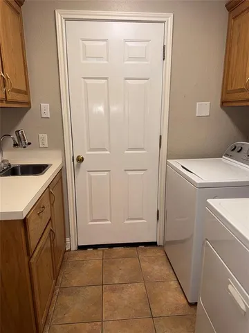 a utility room with cabinets washer and dryer