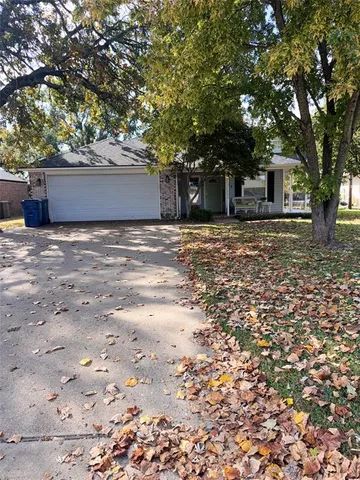 a front view of a house with a tree