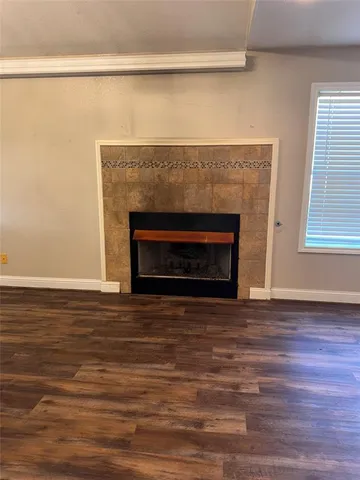 a view of empty room with wooden floor and a fireplace