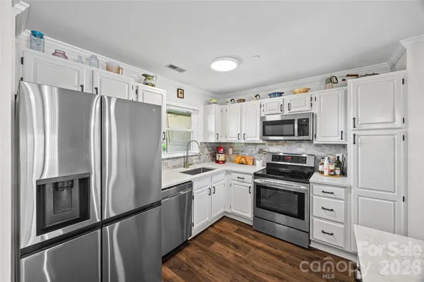 a kitchen with white cabinets and white appliances