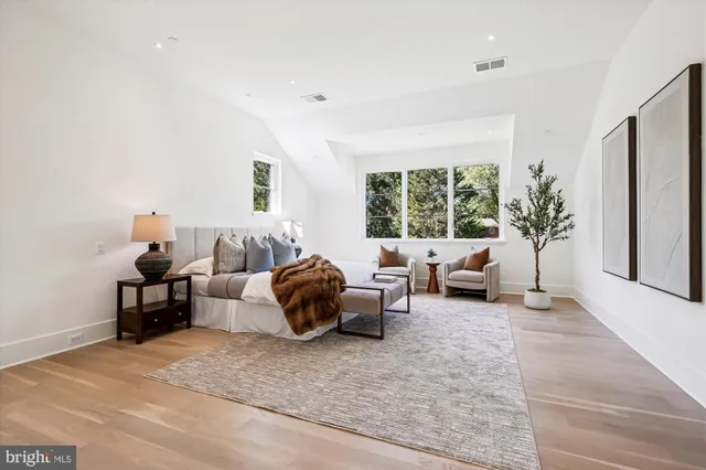 a spacious bedroom with a bed a couch and a dresser