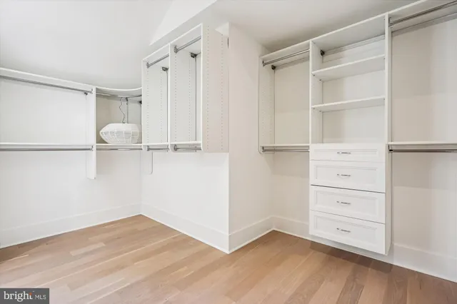 a view of walk in closet with empty racks