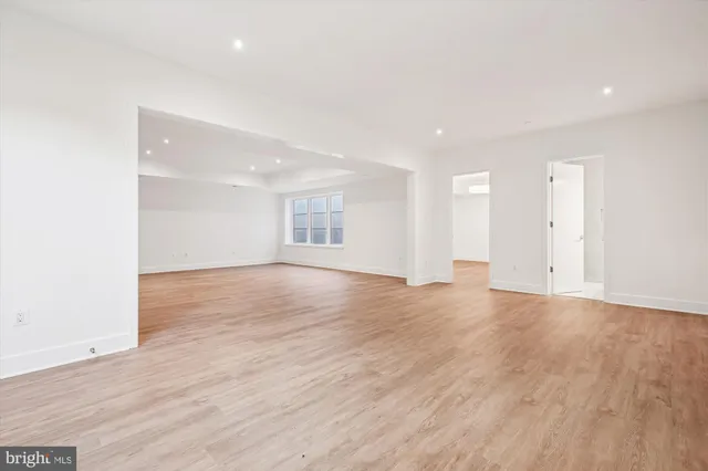 a view of empty room with wooden floor and window