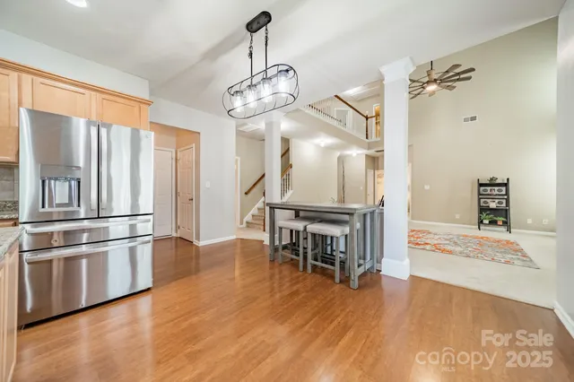 a kitchen with stainless steel appliances granite countertop a refrigerator a stove and a wooden floors