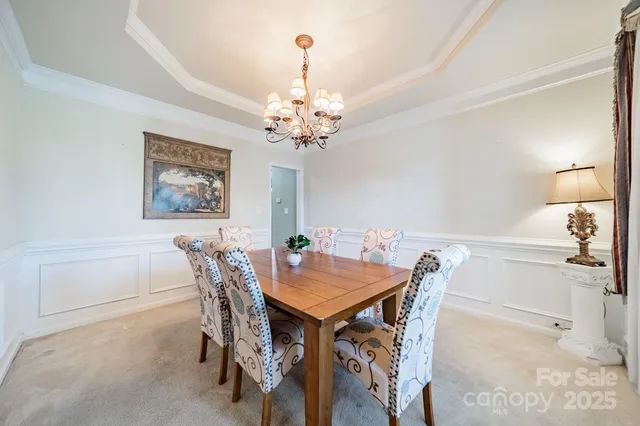 a view of a dining room with furniture and a chandelier