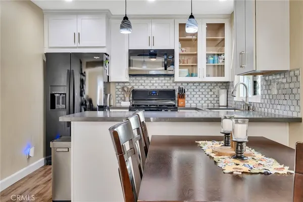 a kitchen with stainless steel appliances granite countertop a stove refrigerator and cabinets