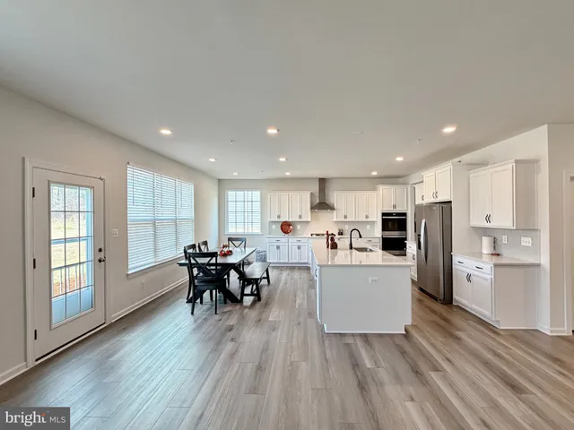 a kitchen with stainless steel appliances a refrigerator a microwave and cabinets