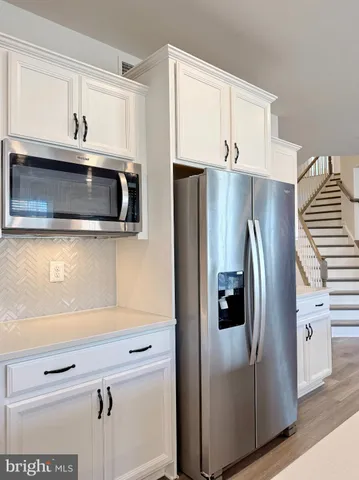 a view of staircase with wooden floor and white walls