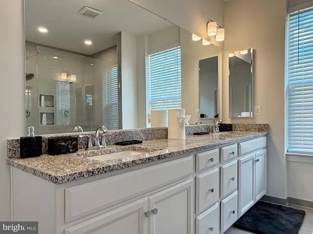 a bedroom with a bed and a dresser next to a window