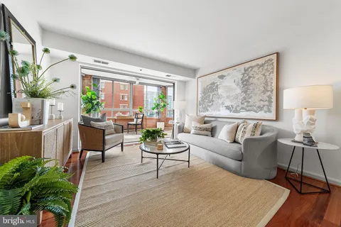 a living room with furniture and a large window with wooden floor