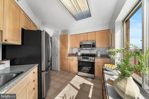 a kitchen with stainless steel appliances granite countertop a refrigerator sink stove microwave and cabinets