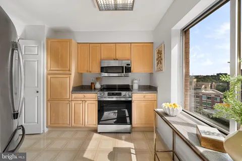 a kitchen with stainless steel appliances granite countertop a stove top oven a sink and a refrigerator
