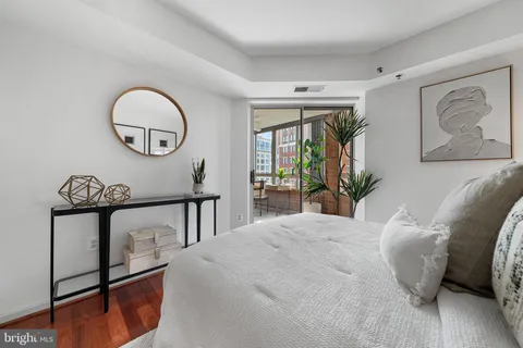 a bedroom with bed and a painting on the wall