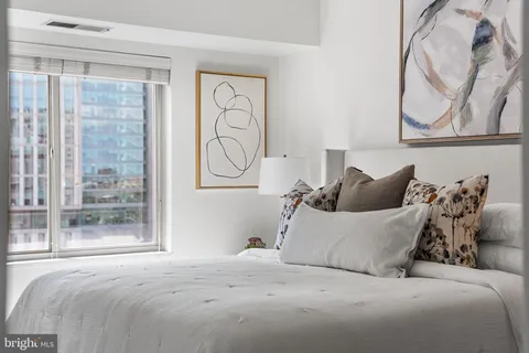 a bed room with a bed and a painting on the wall