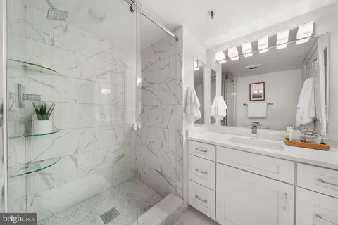 a bathroom with a double vanity sink mirror and shower
