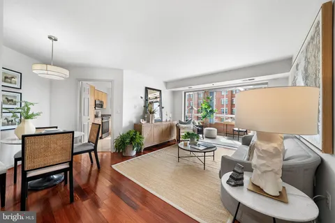 a living room with furniture a window and wooden floor