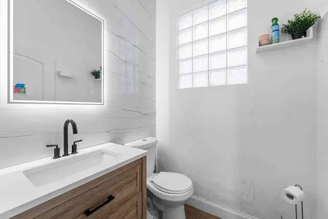 a bathroom with a sink a toilet and a window