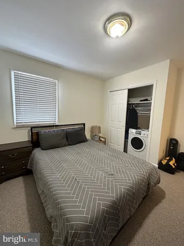 a bedroom with a bed and a large window