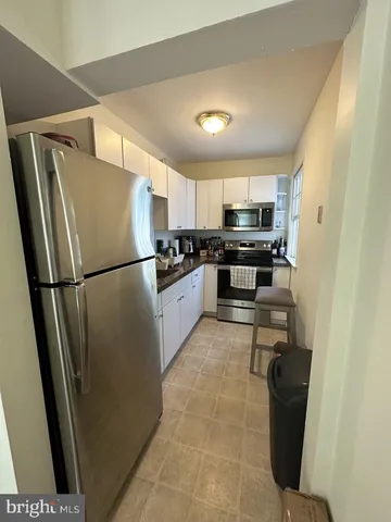 a kitchen with granite countertop a refrigerator and a sink